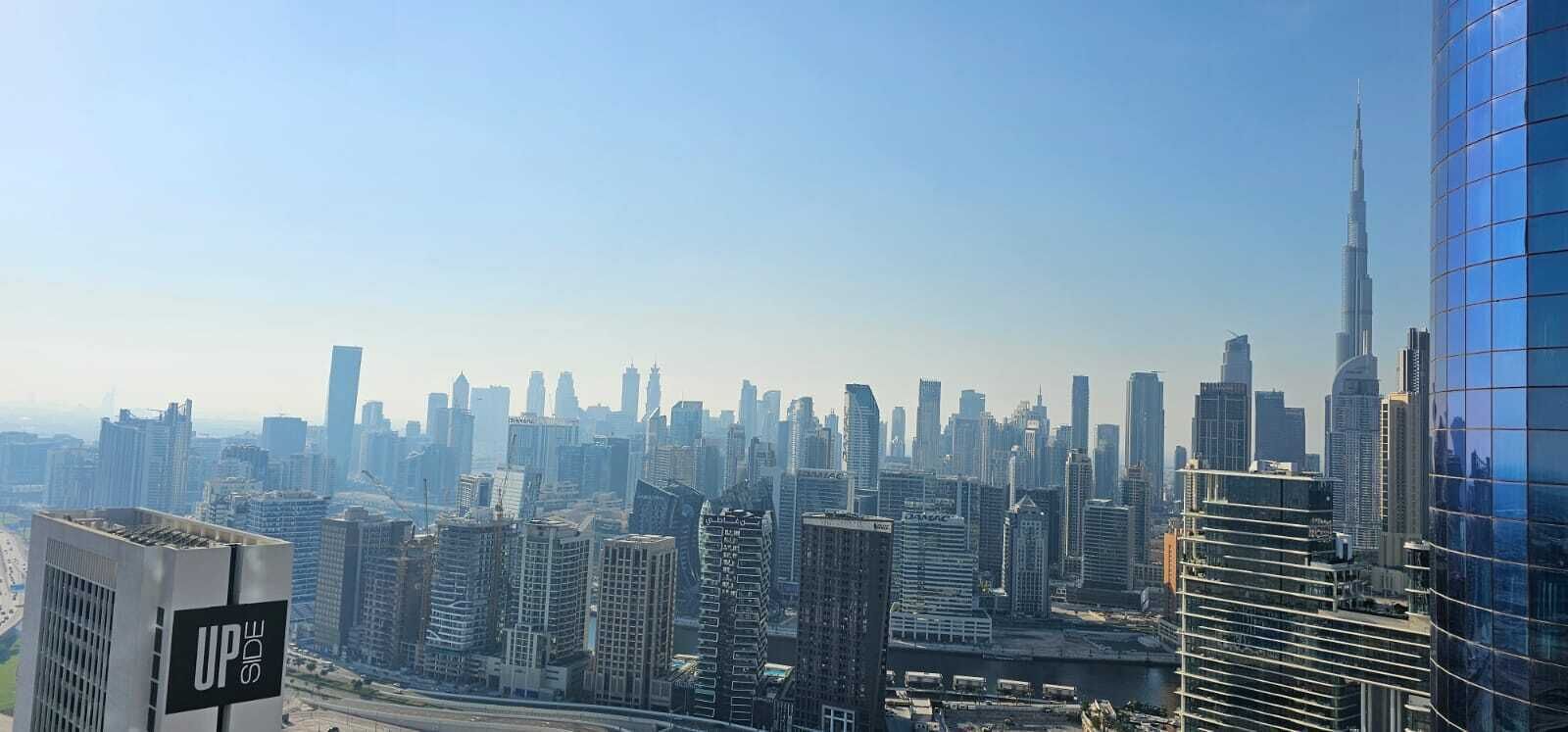 A cityscape with a variety of high-rise buildings, including a prominent skyscraper.