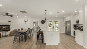 A modern kitchen with white cabinets, a stainless steel refrigerator, and a built-in oven. - 4 Brdm / 6 Beds / Pool / PetsOK / Fenced Yard (Scottsdale)