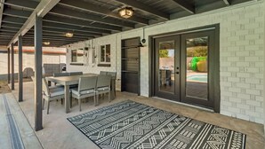An outdoor patio with a dining table and chairs, a patterned rug, and a brick wall. - 4 Brdm / 6 Beds / Pool / PetsOK / Fenced Yard (Scottsdale)