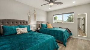 A bedroom with two beds, a ceiling fan, a window, and a door. - 4 Brdm / 6 Beds / Pool / PetsOK / Fenced Yard (Scottsdale)
