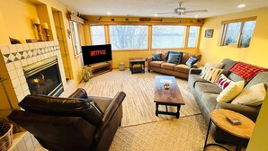 A living room with a fireplace, a television, a sofa, and a coffee table.