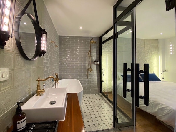 Un baño moderno con un espejo grande, dos lavamanos y una bañera.