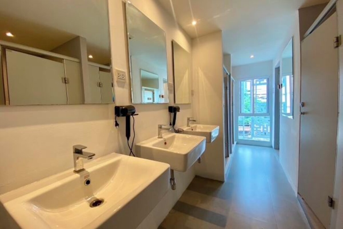 A modern bathroom with two sinks, mirrors, and a hallway leading to a balcony.