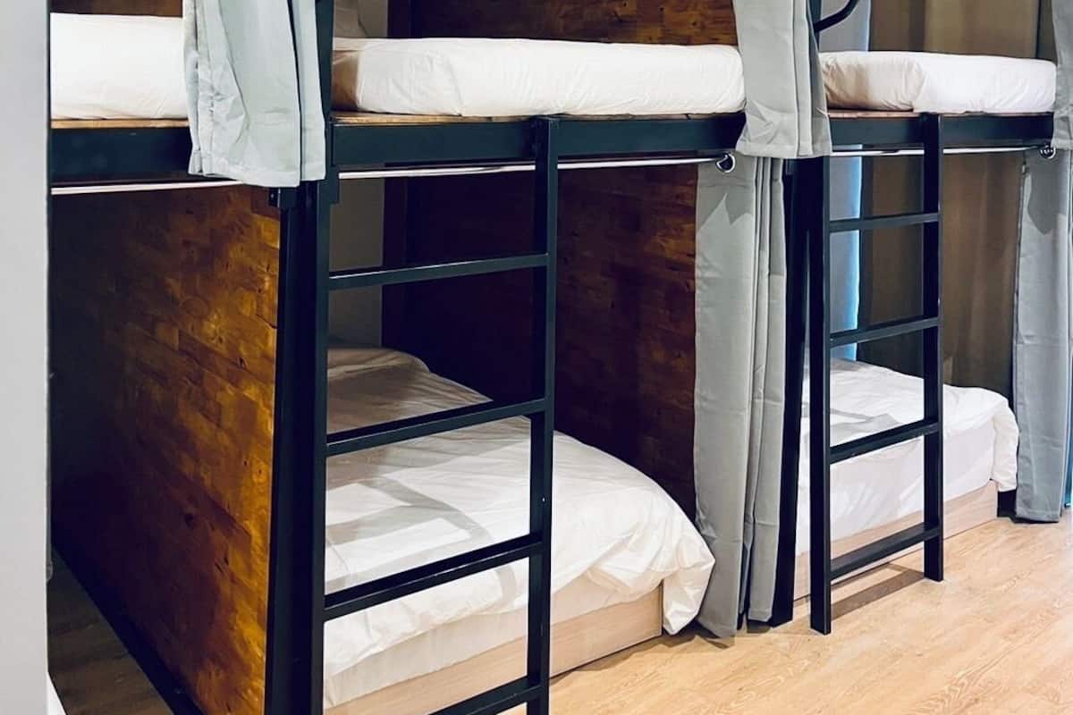 A bunk bed room with wooden walls and curtains.