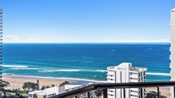 Ein Hotel direkt am Strand mit Blick auf das Meer und einen klaren Himmel.