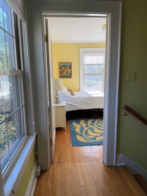Une chambre à coucher avec un lit, une table de chevet, une lampe et un tableau au mur.
