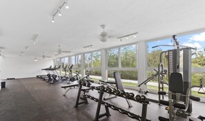 A gym with cardio machines, free weights, and a view of greenery outside. - Altamar: Penthouse Near Beach with Gym & Pool (Nuevo Nayarit)
