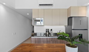 A modern kitchen with a microwave, coffee maker, and a refrigerator. - Altamar: Penthouse Near Beach with Gym & Pool (Nuevo Nayarit)