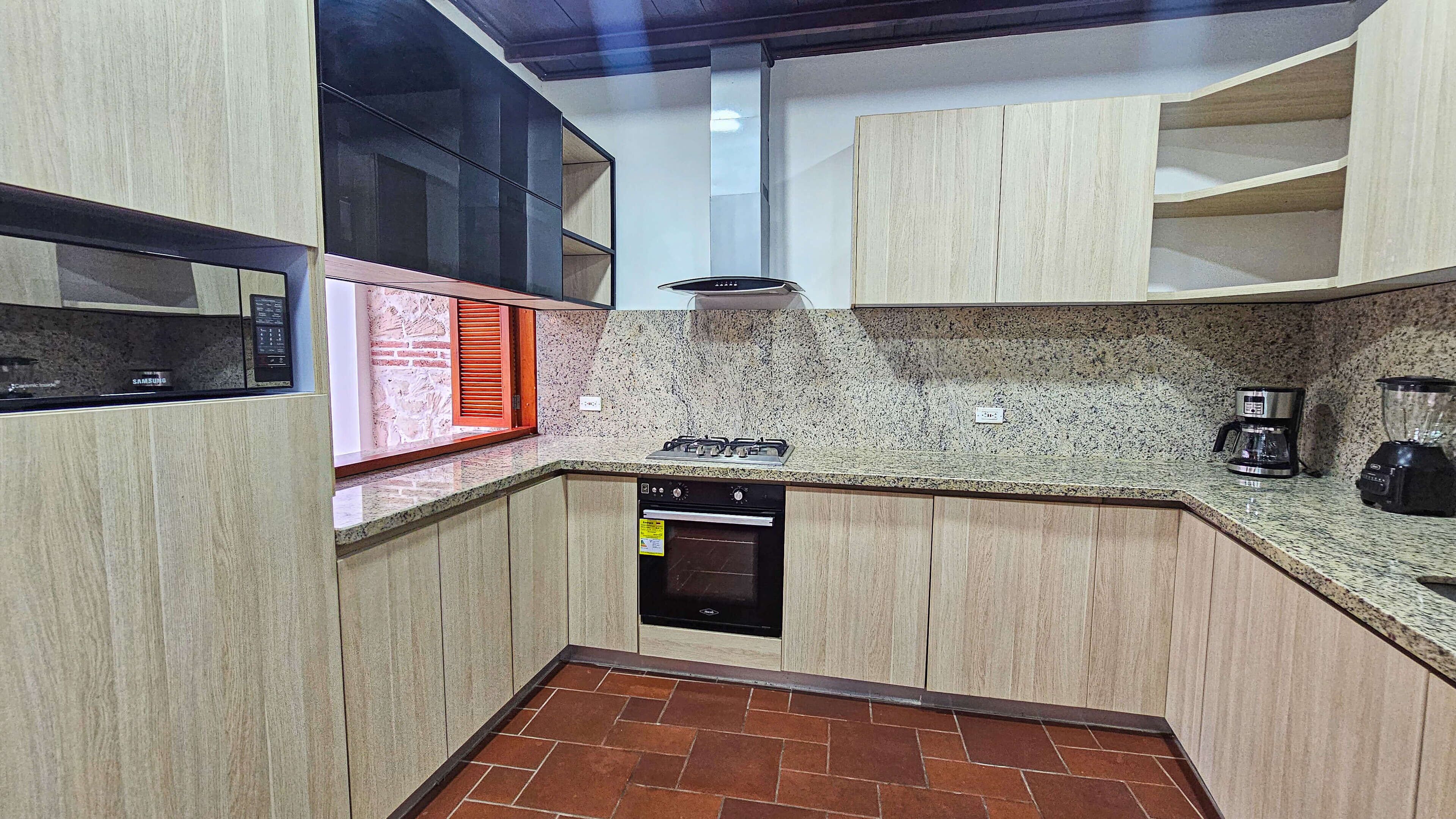 A compact kitchen with a built-in microwave, gas stove, and dishwasher.