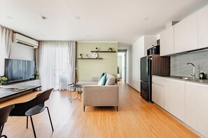 A modern apartment with a kitchen, dining area, and living room.