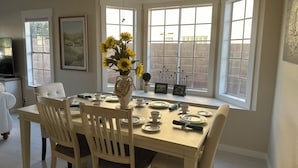 A dining area with a table set for four, surrounded by large windows. - Remodeled 3 bedroom house in Mesa w/heated pool and golf course views (Mesa)