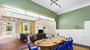A dining area with a long table set for six, surrounded by blue chairs. - Fitzroy Private Rooms @ 132 Nicholson Homestay (Fitzroy)