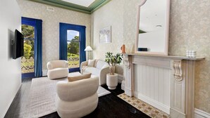 A room with a fireplace, a large mirror, and a view of the outdoors through a window with blue curtains. - Fitzroy Private Rooms @ 132 Nicholson Homestay (Fitzroy)