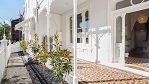 A white building with ornate white railings and a tiled entrance. - Fitzroy Private Rooms @ 132 Nicholson Homestay (Fitzroy)