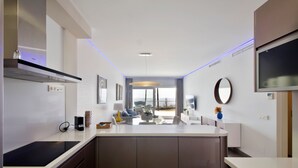 A modern kitchen with a central island, built-in appliances, and a dining area with a view.
