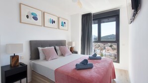 Ein modernes Schlafzimmer mit einem Bett, Nachttischen, einem Deckenventilator und einem Fenster mit Blick auf die Stadt.
