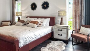 A bedroom with a bed, bedside tables, a chair, a rug, and curtains. - Escape to a luxurious one-bedroom lodge designed exclusively for couples. (Chipping)