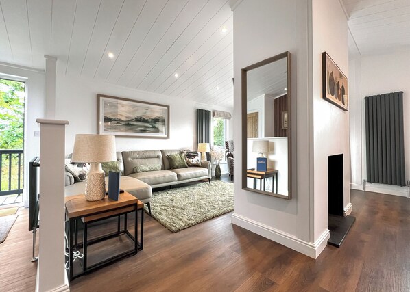 A living room with a sofa, a coffee table, a fireplace, and a large mirror.