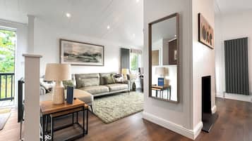 Un salon comprenant un canapé, une table basse, une cheminée et un grand miroir.