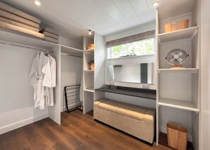 A walk-in closet with shelves, a mirror, and a radiator.