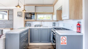 A modern kitchen with grey cabinets, a built-in microwave, a gas stove, and a no-smoking sign. - Coldstream Retreat - 3 Bedroom (Pet Friendly) (Coldstream)