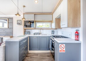 A modern kitchen with grey cabinets, a built-in microwave, a gas stove, and a no-smoking sign. - Coldstream Retreat - 3 Bedroom (Pet Friendly) (Coldstream)