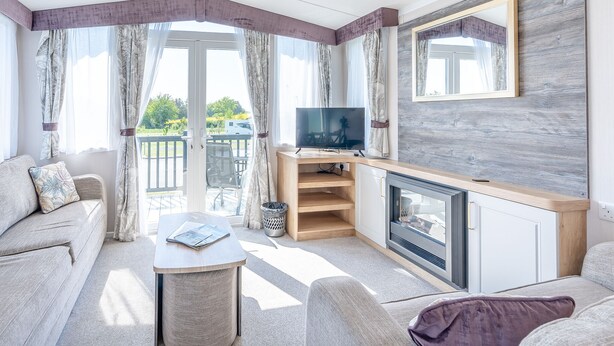 A modern living room with a sofa, a coffee table, a TV, and a fireplace. - Coldstream Retreat - 3 Bedroom (Pet Friendly) (Coldstream)