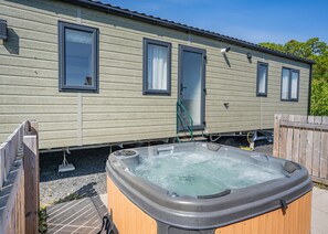 A mobile home with a hot tub in front, a door, and windows. - Cheviot Retreat - 2 Bedroom (Pet Friendly) (Coldstream)