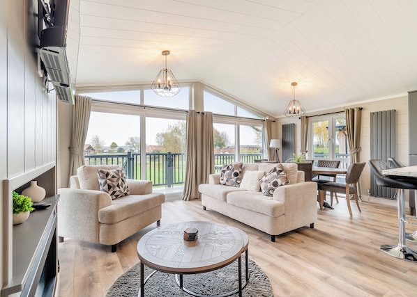 A spacious living area with a sofa set, a dining table, and a coffee table.