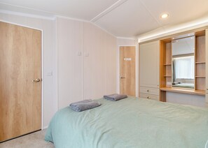 Un dormitorio con cama, armario y espejo.