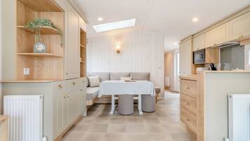 A compact kitchen with a dining area, wooden cabinets, and a skylight.