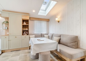 A cozy room with a sofa, a table, and a built-in cabinet. - Family and dog friendly lodge. (Swinethorpe, Nr Lincoln)
