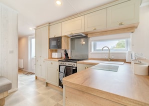 A modern kitchen with a built-in oven, microwave, and sink. - Family and dog friendly lodge. (Swinethorpe, Nr Lincoln)