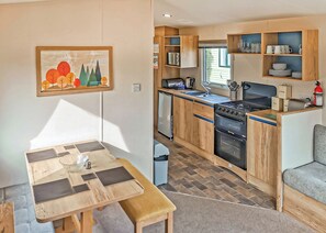 A compact kitchen with wooden cabinets, a stove, and a sink.