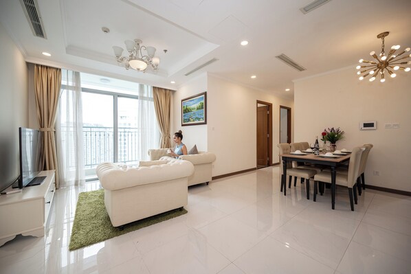 Relax in this stylish living room with a sofa, dining table, and flat-screen TV.