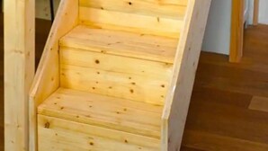 A wooden staircase with a simple design, leading to an upper level.