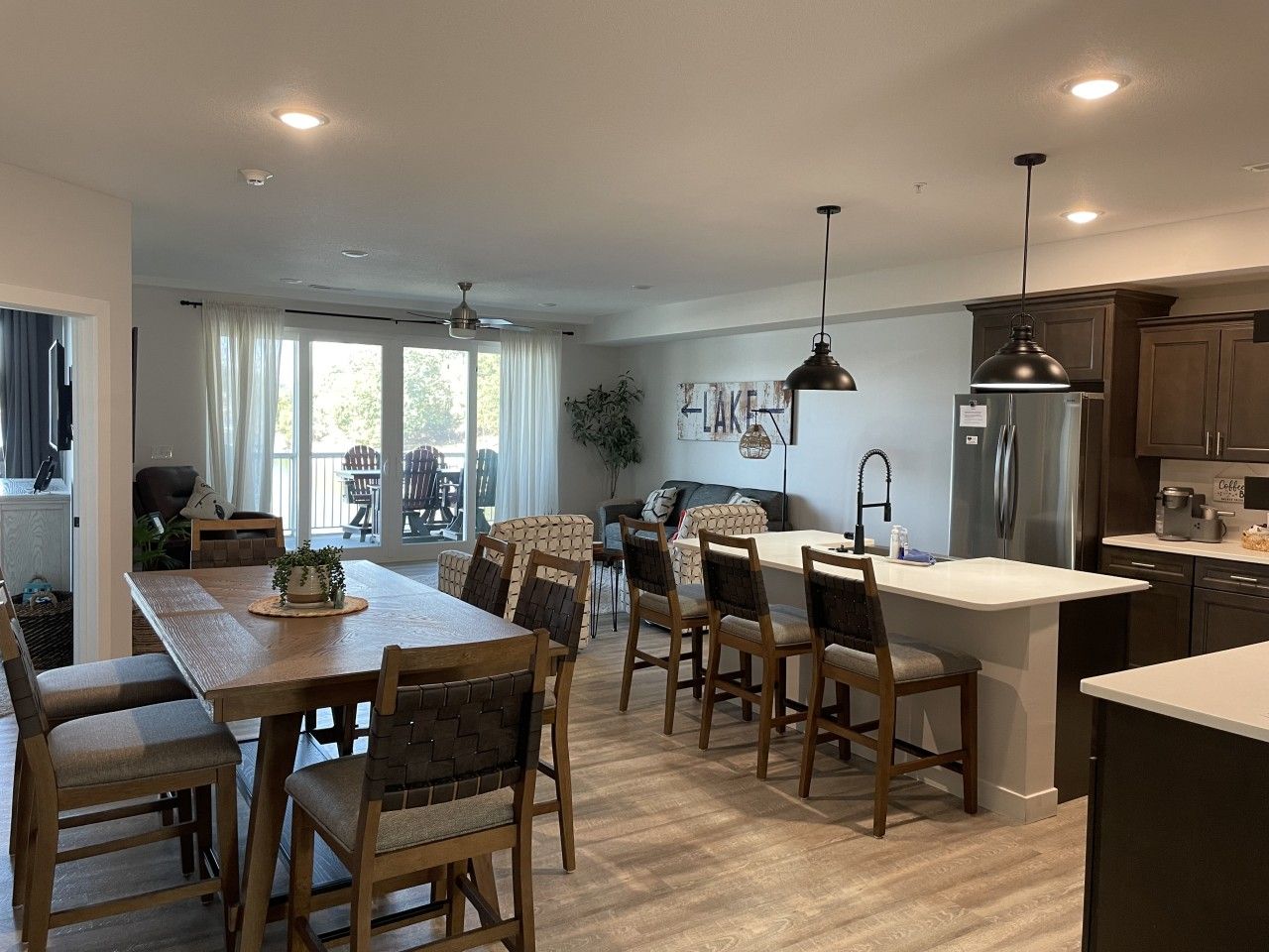Une cuisine moderne avec un coin repas, des meubles en bois et une vue sur l’extérieur.