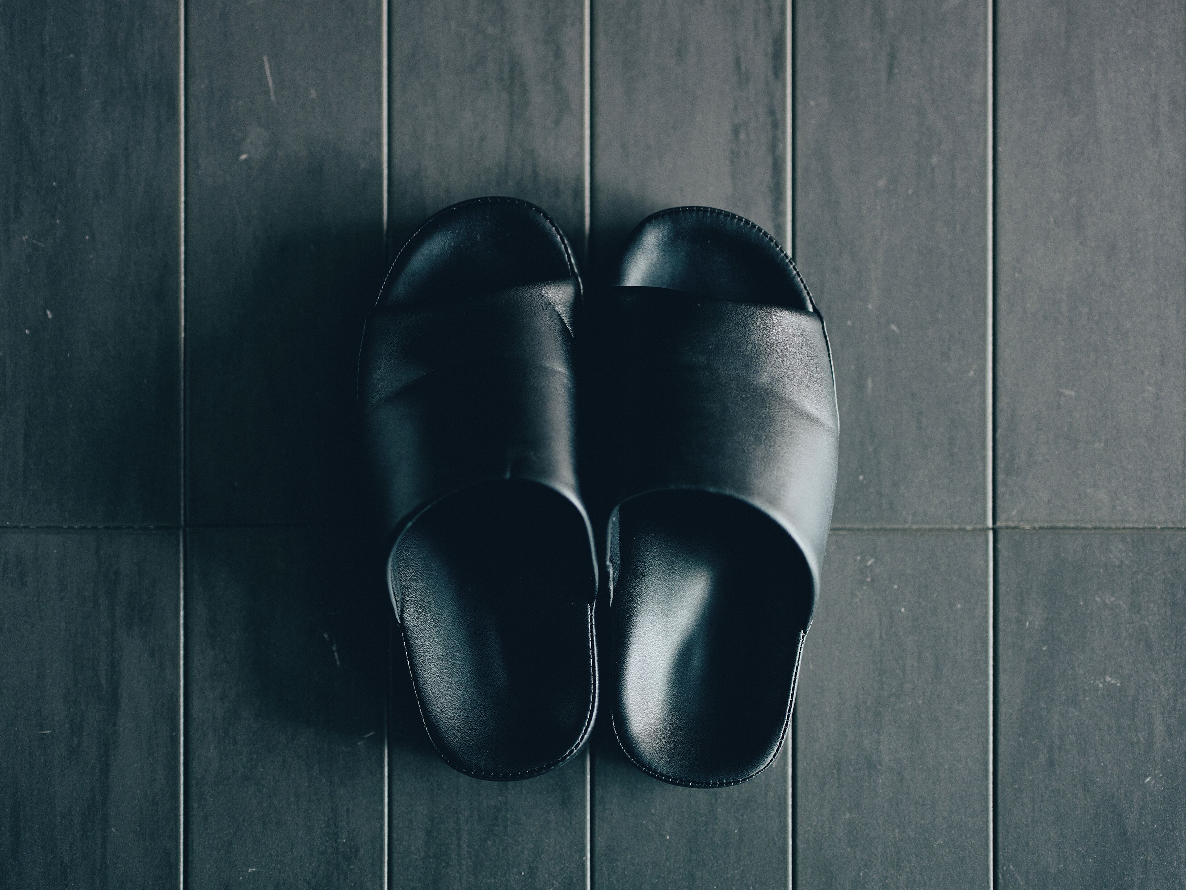 Une paire de chaussures noires sur un sol carrelé.