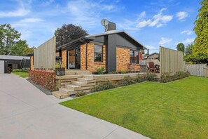 A modern house with a brick facade, a satellite dish, and a well-maintained lawn.