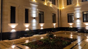 Un amplio vestíbulo de hotel con un patio central, ventanas grandes y arquitectura clásica.