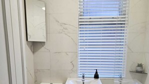 A bathroom with a toilet, sink, and bathtub. - Home Away from Home (Coventry)