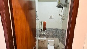 A small bathroom with a toilet, sink, and shower.