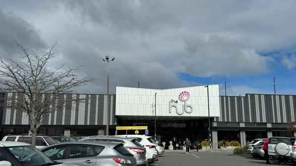 A parking lot with cars and a building with a 'The Hub' sign.