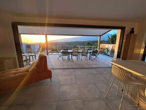 Eine moderne Außenpatio mit Essbereich, einer Couch und einer Bar.