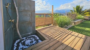 A wooden deck with a view of mountains and a pool area with a shower. - Villa Eclats Panoramiques (Saint-Pierre)