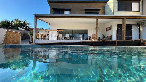 A modern house with a swimming pool, outdoor seating, and a covered patio area. - Villa Eclats Panoramiques (Saint-Pierre)