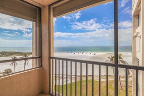 A balcony with a view of a beach and ocean.