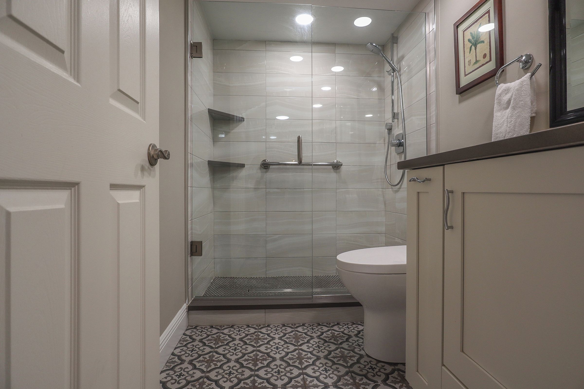 A bathroom with a shower, toilet, and vanity.