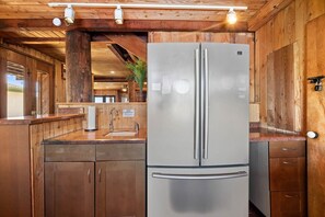 Una cocina moderna con muebles de madera, un refrigerador de acero inoxidable y un lavamanos integrado.