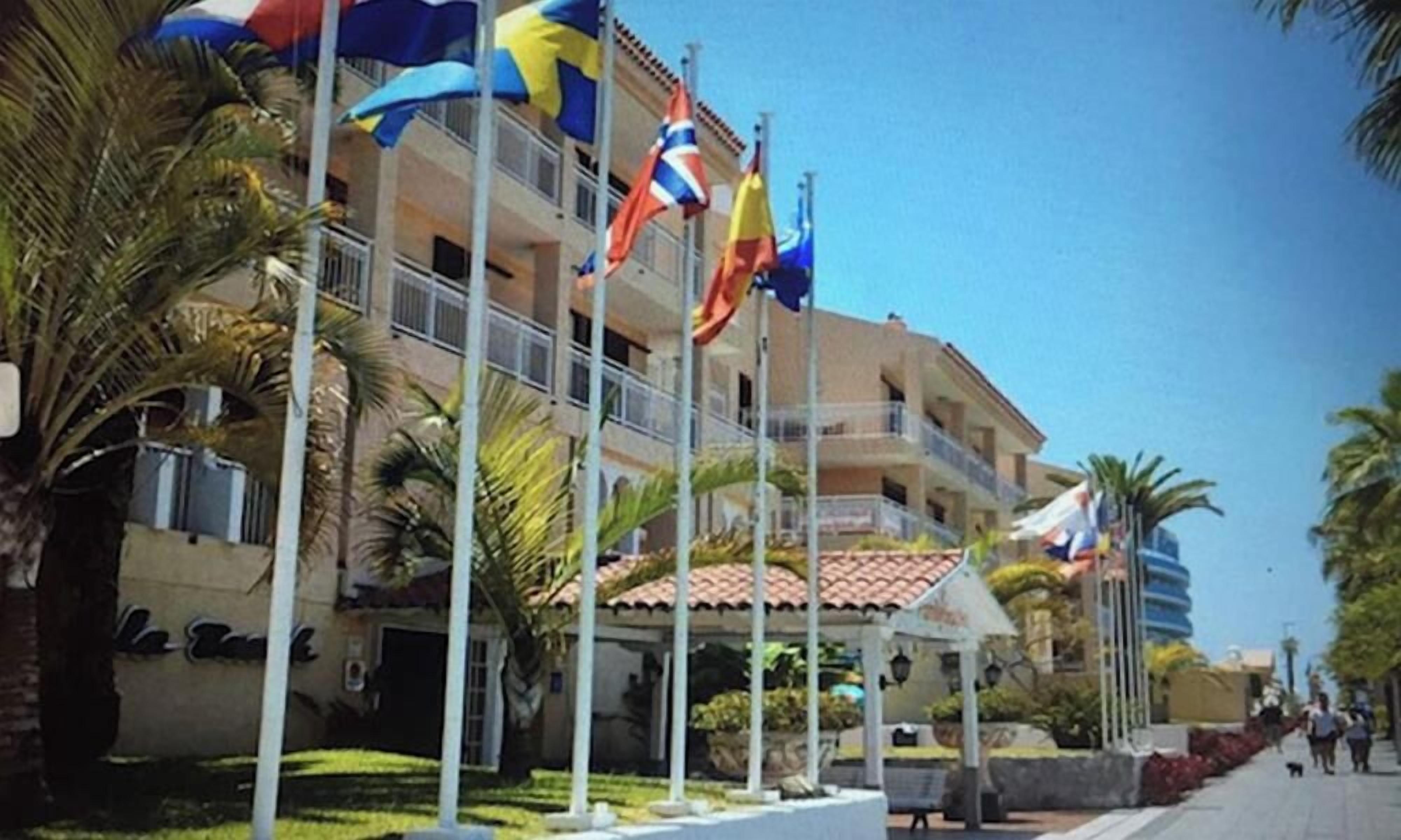 Un hôtel arborant plusieurs enseignes, un espace extérieur couvert et une rue piétonne.